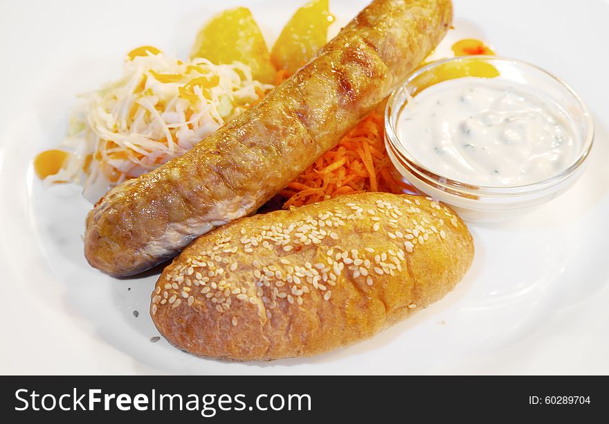 Fresh sausages with vegetables on a plate closeup