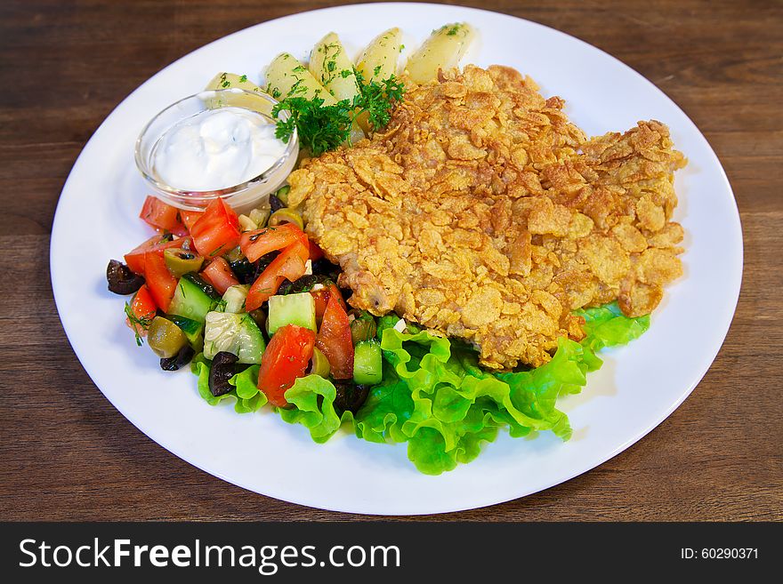 Meat casserole with vegetables and sauce on a plate closeup. Meat casserole with vegetables and sauce on a plate closeup