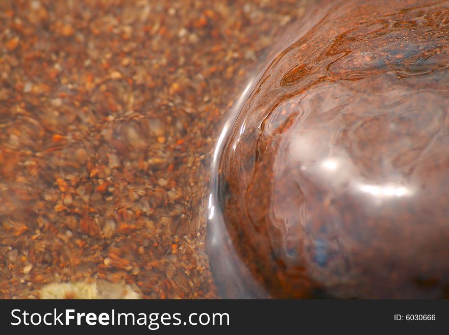 Close up of a pebble in water, slightly slow exposure.