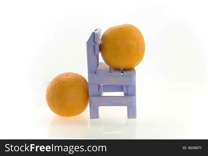 Composition from two fresh natural orange and a wooden small chair. Composition from two fresh natural orange and a wooden small chair