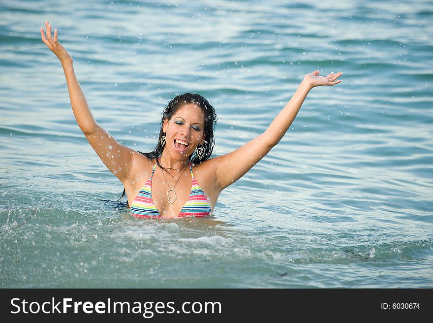 Beautiful Young Woman Having Fun Splashing in the Ocean