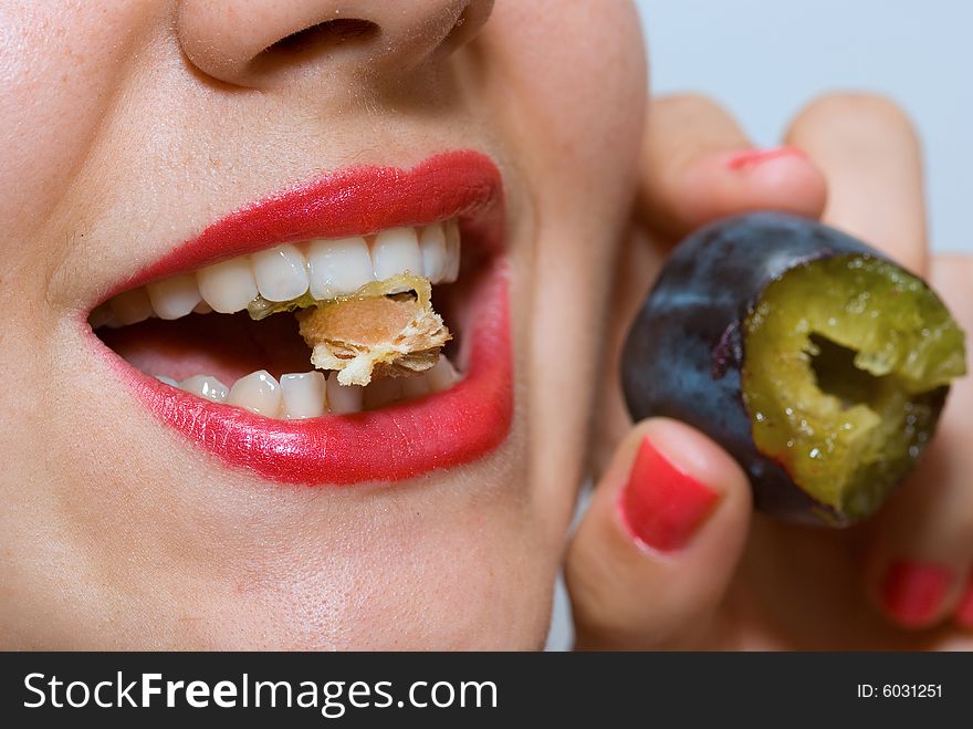 Attractive girl with red lipstick, eating a plum. Attractive girl with red lipstick, eating a plum