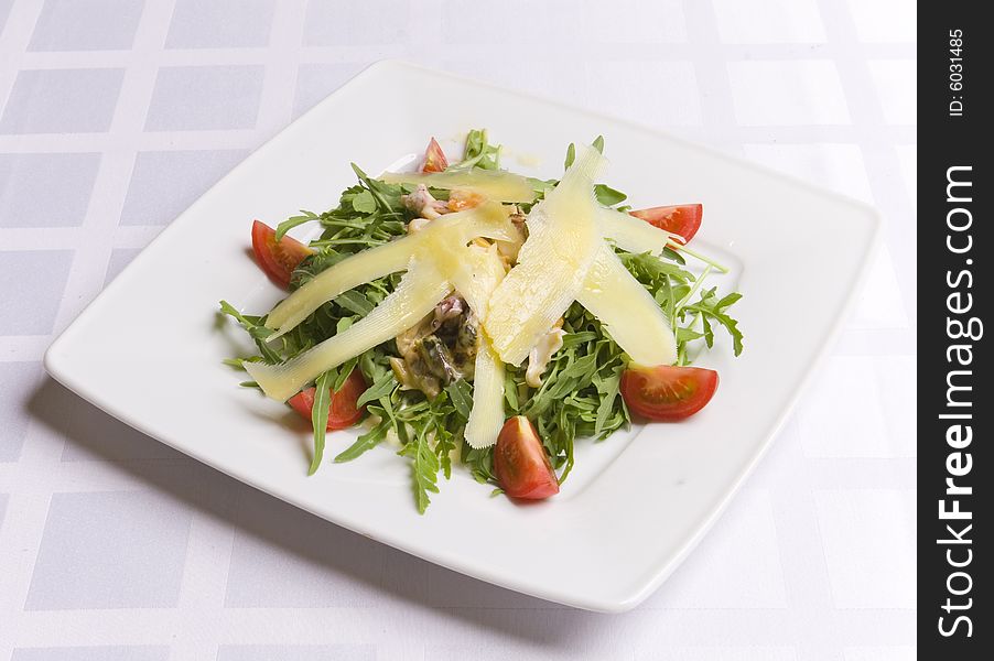 Salad with cheese and vegetables on white plate