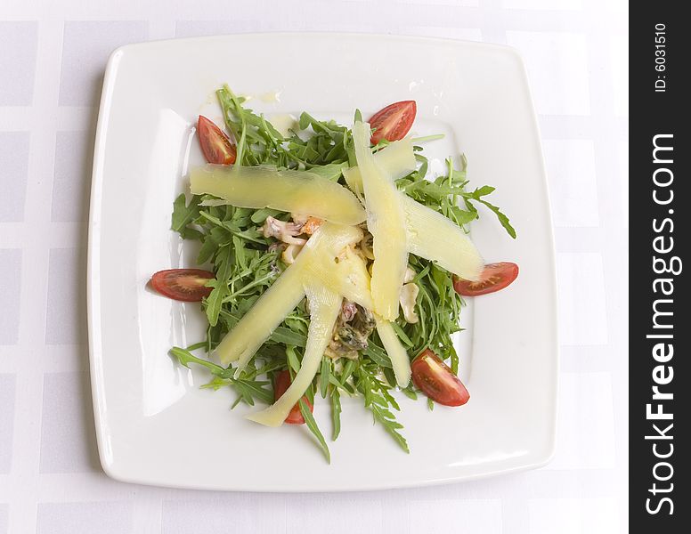Salad with cheese and vegetables on white plate
