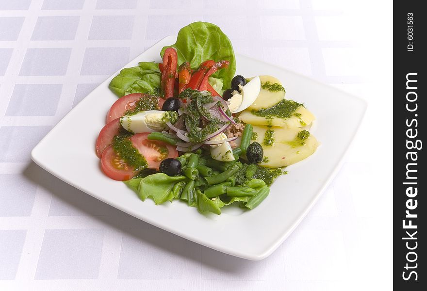 Salad with vegetables and eggs on white plate