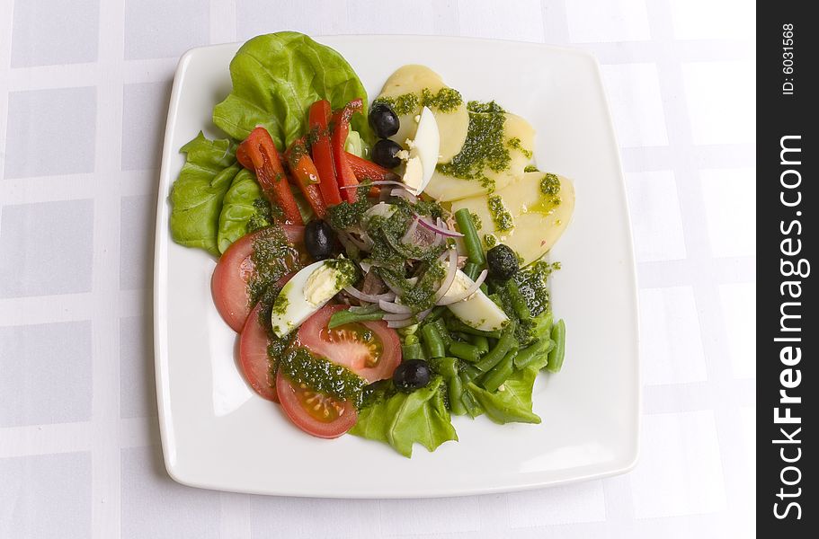 Salad with vegetables and eggs on white plate