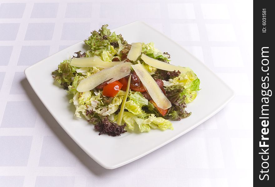 Salad with cheese and vegetables on white plate