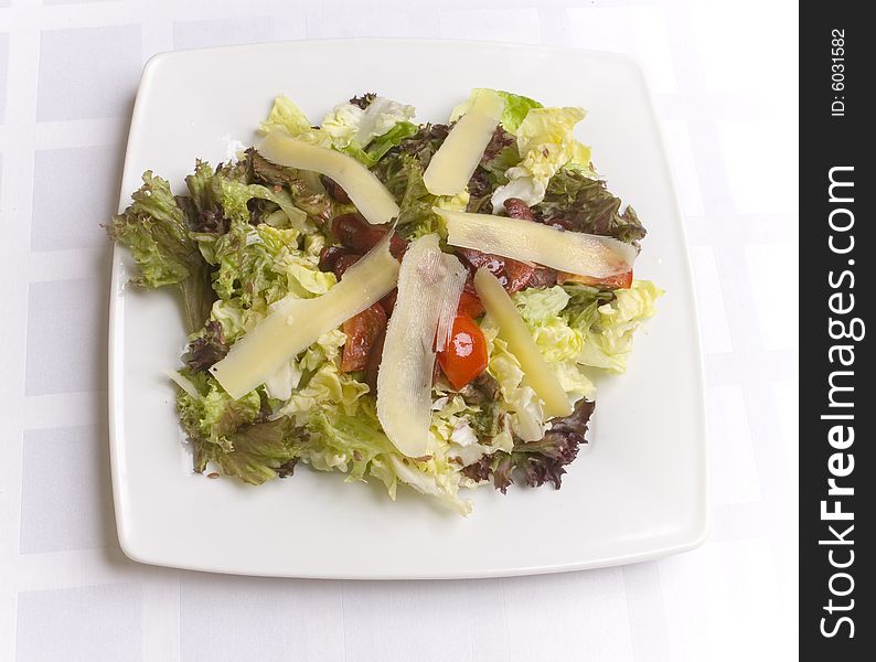 Salad with cheese and vegetables on white plate