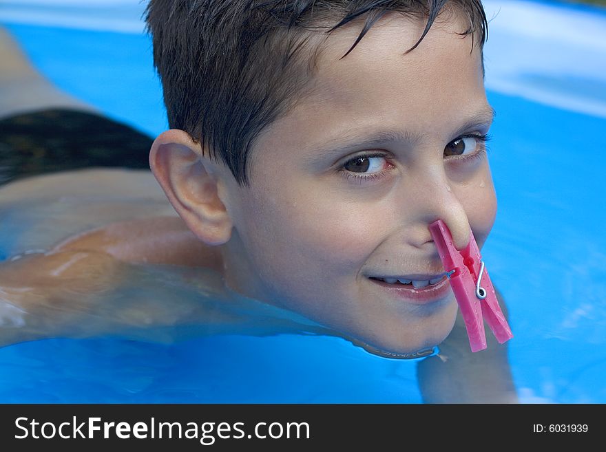 Young boy in pool  with peg