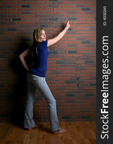 Woman next to brick wall pointing to area for user supplied text