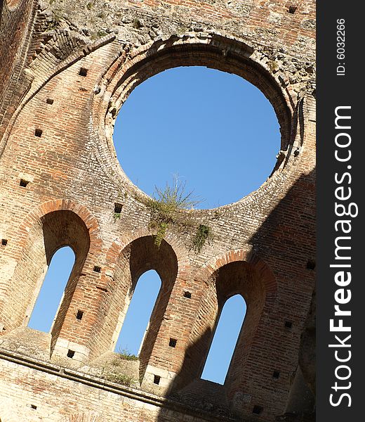 A particular shot of the ruin of the rose window and some windows of the apse in San Galgano abbey. A particular shot of the ruin of the rose window and some windows of the apse in San Galgano abbey