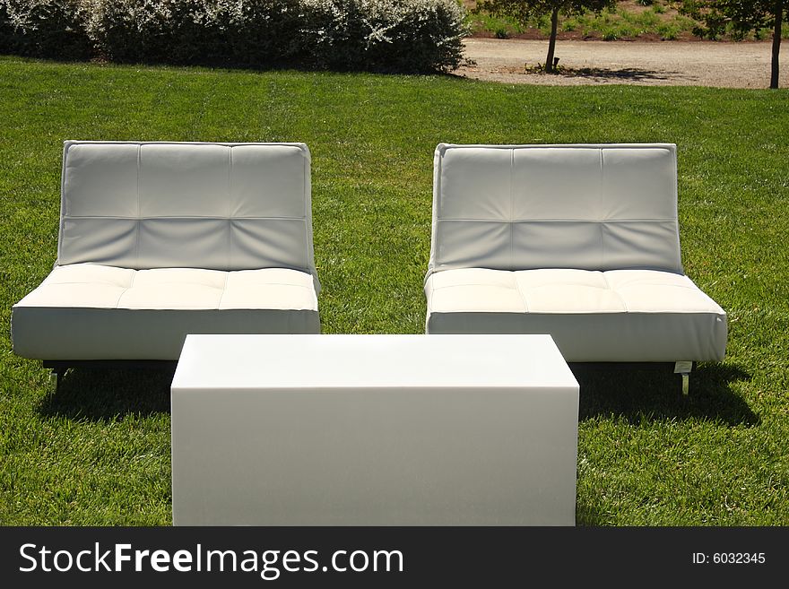 White chairs set up outside on lawn. White chairs set up outside on lawn