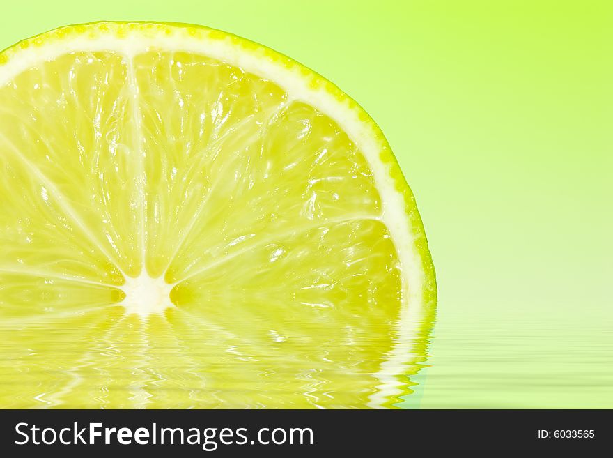 Fresh slice of lime on water reflection and zesty green gradient lighting. Fresh slice of lime on water reflection and zesty green gradient lighting