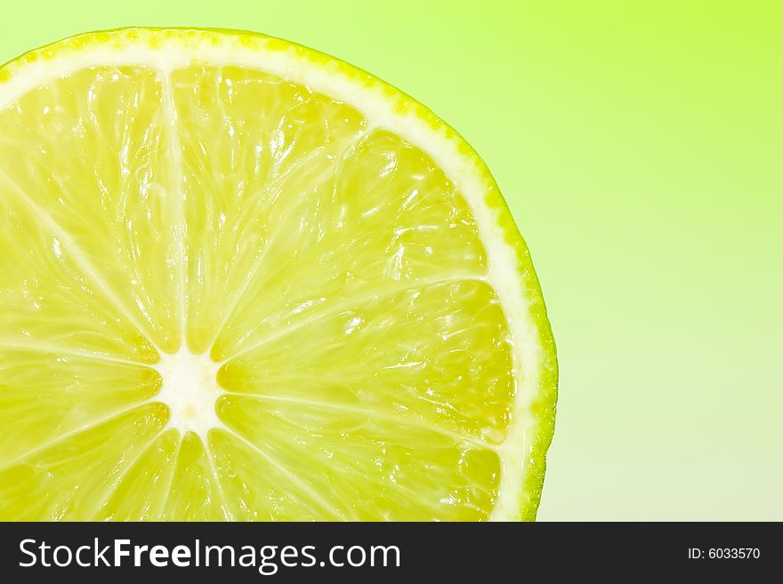 Fresh slice of lime with zesty green gradient lighting. Fresh slice of lime with zesty green gradient lighting