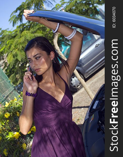 Young woman looking her broken car talking by phone. Young woman looking her broken car talking by phone