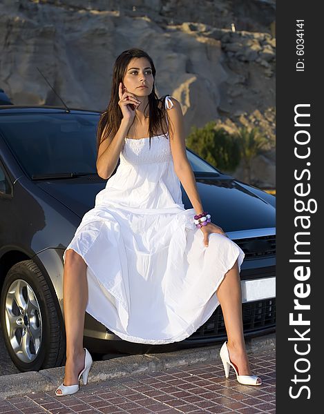 Young woman sitting on her new car