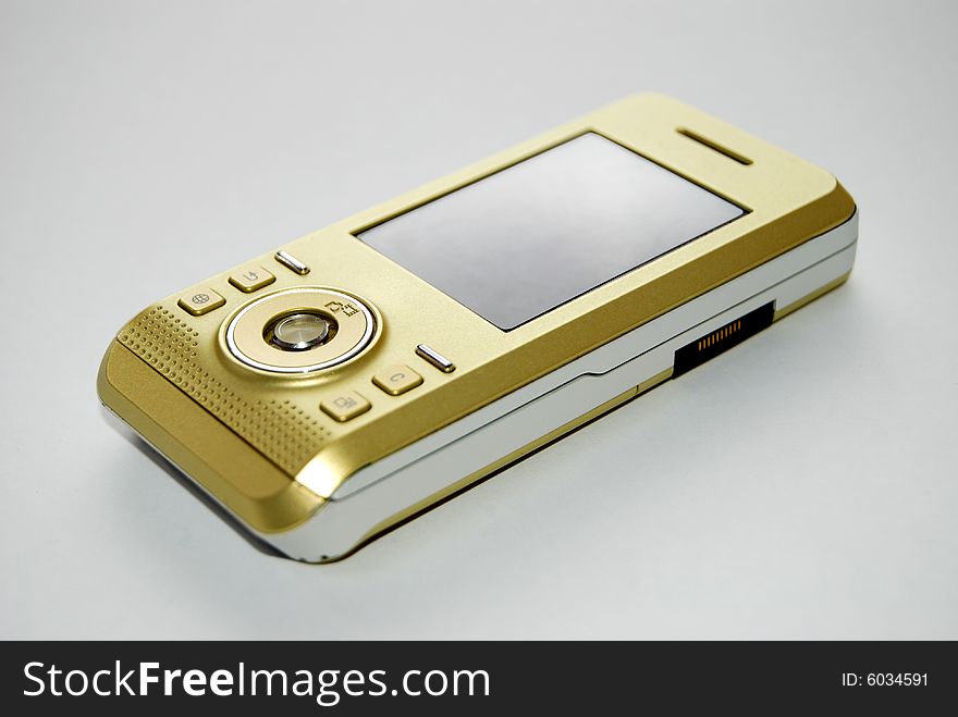 Gold color hand phone with grey background.