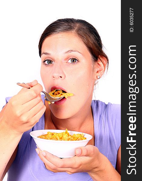 A young woman enjoys her crunchy cornflakes. Isolated over white. A young woman enjoys her crunchy cornflakes. Isolated over white.