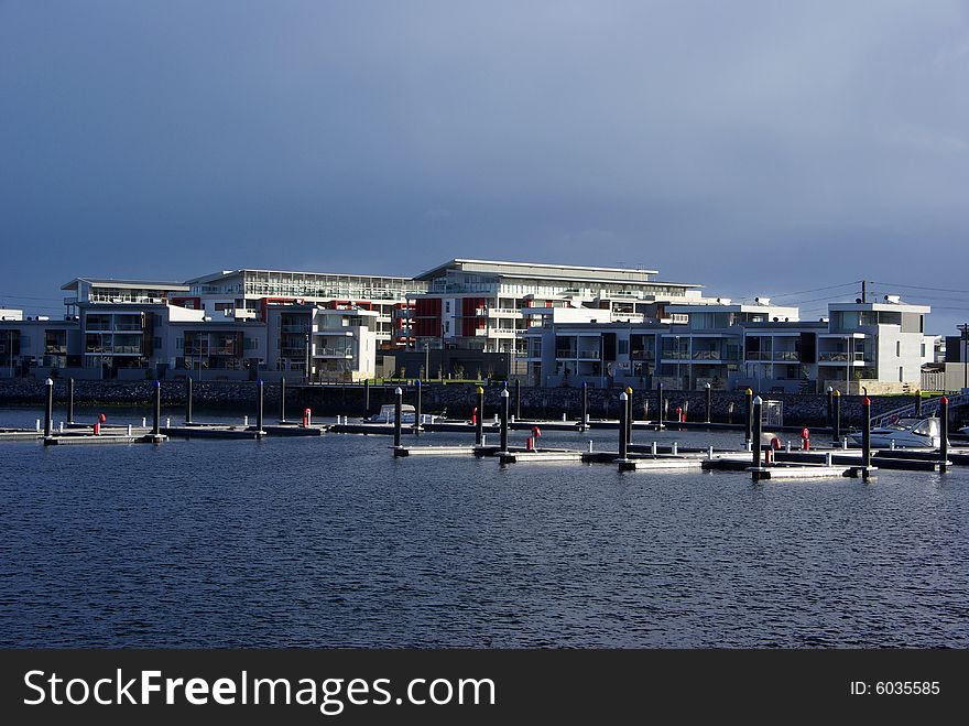 Pontoons floating in the marina front of a block of modern eco style apartments, with a storm brewing overhead. Adelaide, South Australia. Pontoons floating in the marina front of a block of modern eco style apartments, with a storm brewing overhead. Adelaide, South Australia.