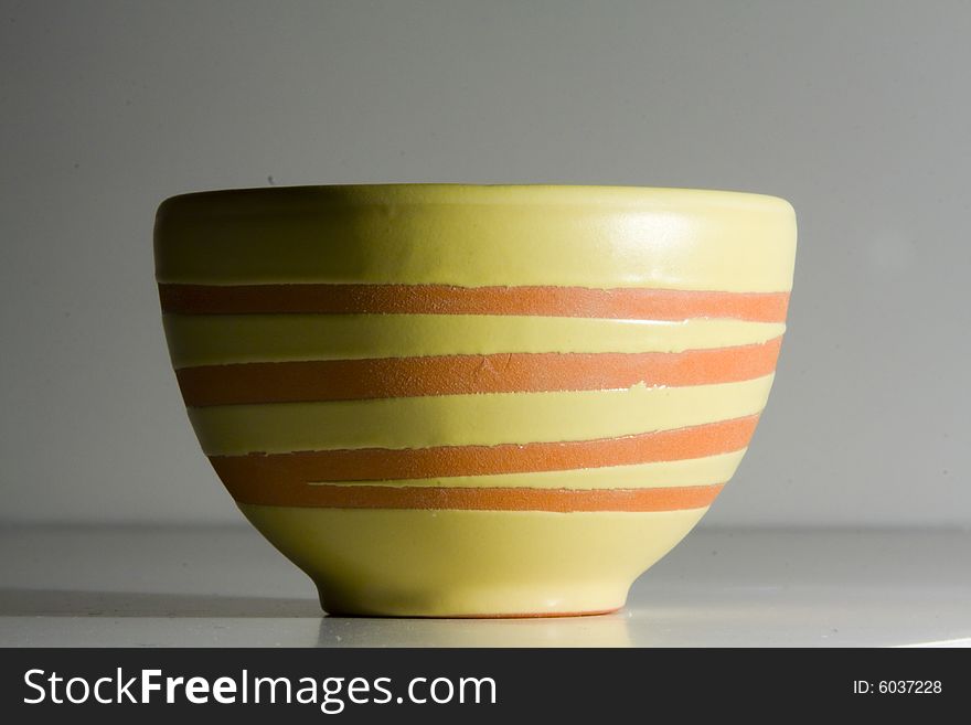 Hand made colorful asian tea cup, isolated against white background and highlighted by single lightsource. Hand made colorful asian tea cup, isolated against white background and highlighted by single lightsource.