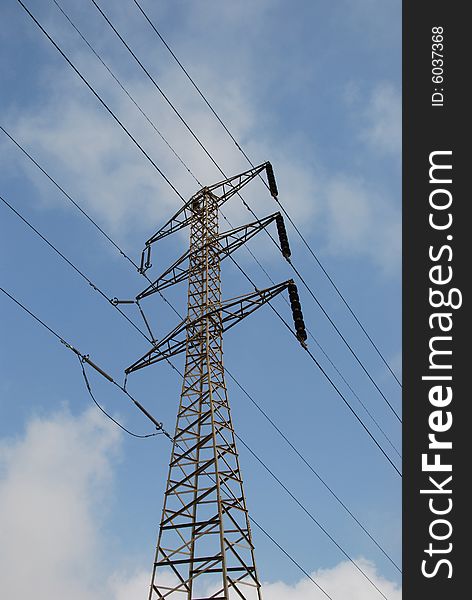 Electrical pylon on background of blue sky and clouds