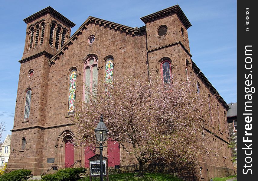 The church and a tree in blossom on a spring day in Newport city, Rhode Island. The church and a tree in blossom on a spring day in Newport city, Rhode Island.