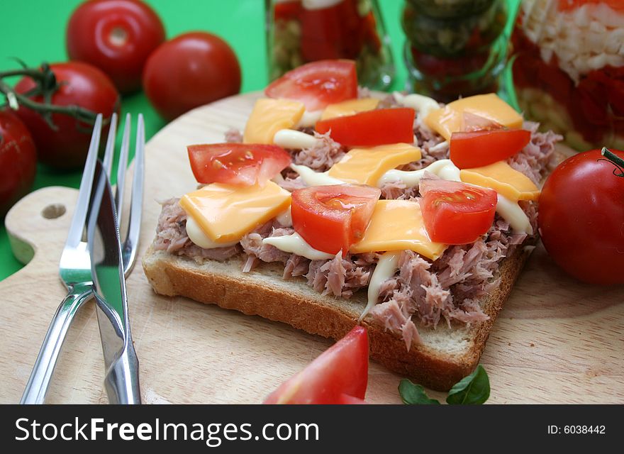 A fresh toast bread with fish, cheese and tomatoes. A fresh toast bread with fish, cheese and tomatoes