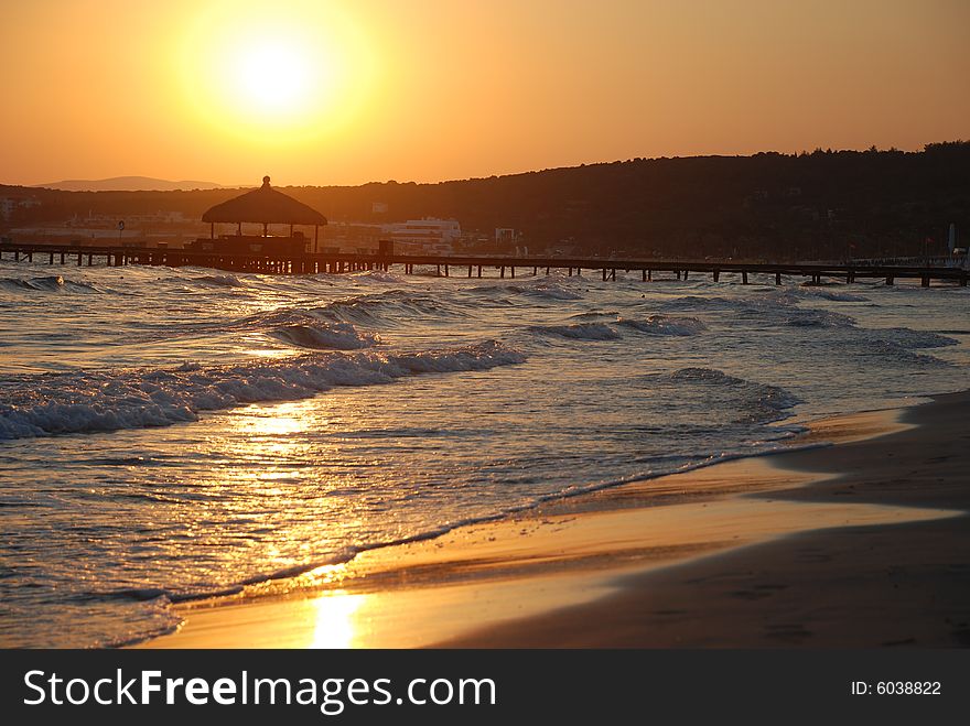 Sunrise on the beach by beach umbrellas and lounge