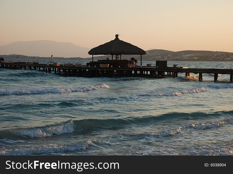 Sunrise on the beach by beach umbrellas and lounge