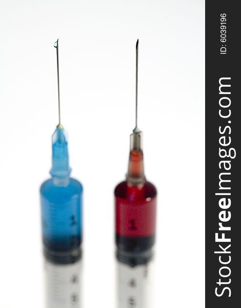 Close up of two colored syringes