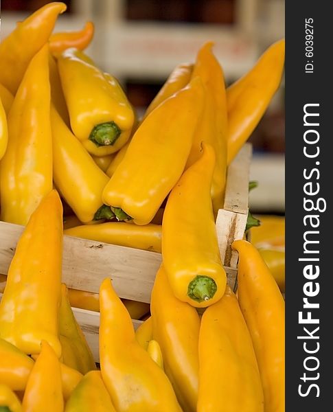 Hot yellow paprika in a box at a market place in italy.