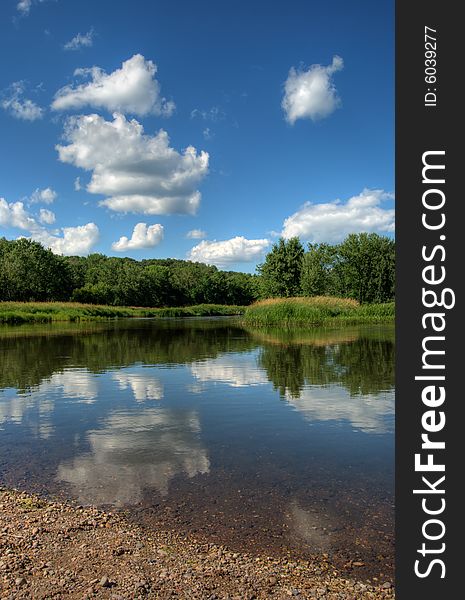 HDR photo of trees and clouds reflecting off the waters surface. HDR photo of trees and clouds reflecting off the waters surface