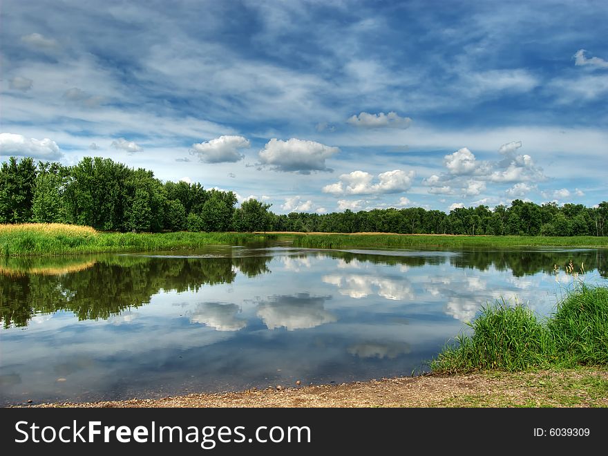 HDR photo of trees and sky reflecting off lake. HDR photo of trees and sky reflecting off lake