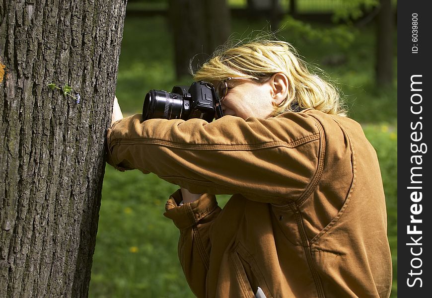 Woman photographer shooting a leaf on a tree