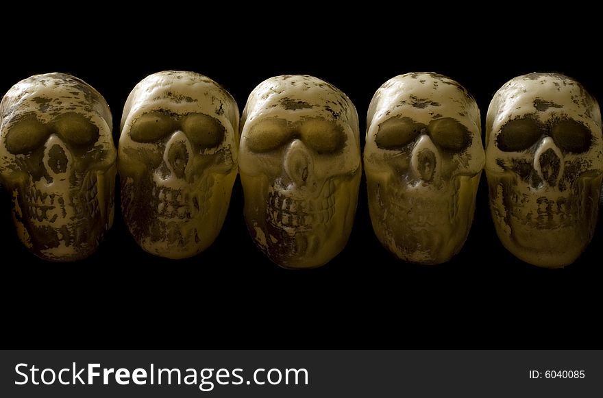 A row of five skulls on isolated black. A row of five skulls on isolated black.