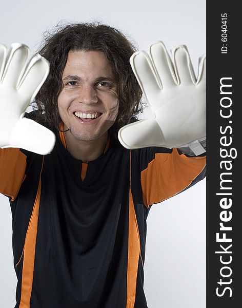 Soccer goalie smiles as he holds his hands up.  Vertically framed photograph. Soccer goalie smiles as he holds his hands up.  Vertically framed photograph