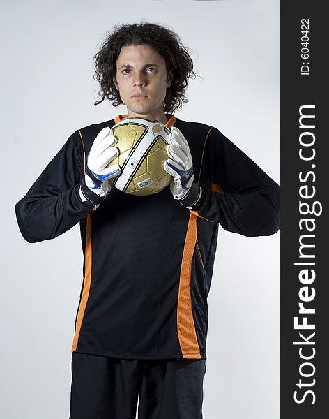 Soccer goalie holds a soccer ball and has a serious look on his face.  Vertically framed photograph. Soccer goalie holds a soccer ball and has a serious look on his face.  Vertically framed photograph