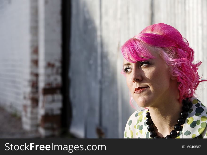 Woman with pink hair in an urban alley. Woman with pink hair in an urban alley