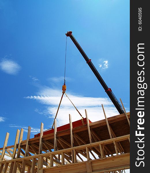 A crane moves wood on a construction site. A crane moves wood on a construction site