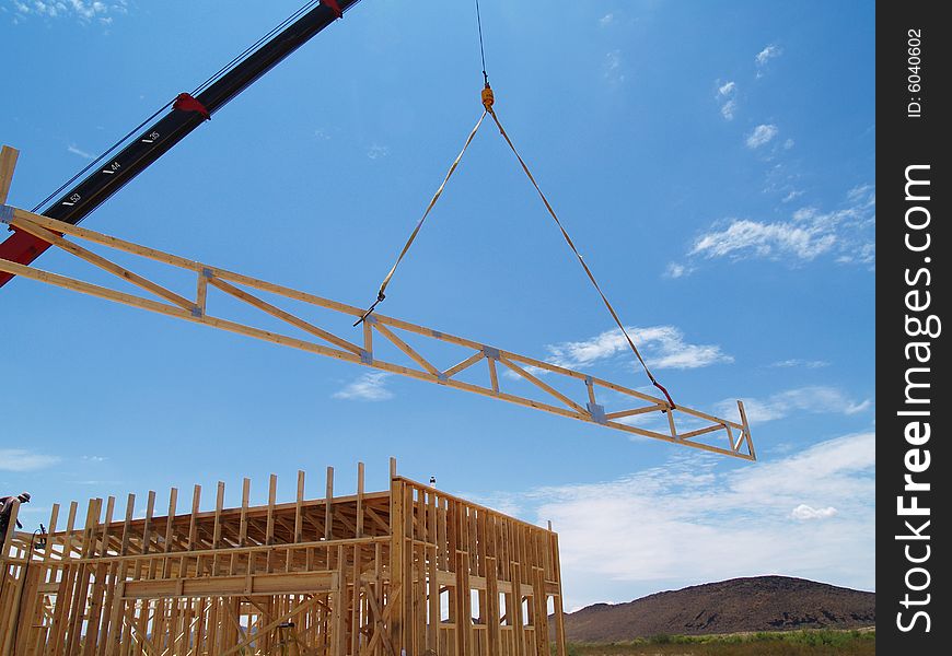 Construction site with a house frame and a crane. Horizontally framed photo. Construction site with a house frame and a crane. Horizontally framed photo.