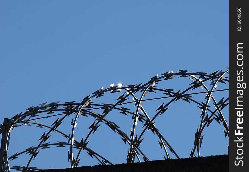 A suggestive shot of wires on the top of an industry's wall