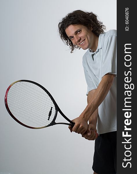 Athlete holding a tennis racket.  He is smiling and looking at the camera.  Vertically framed shot. Athlete holding a tennis racket.  He is smiling and looking at the camera.  Vertically framed shot.