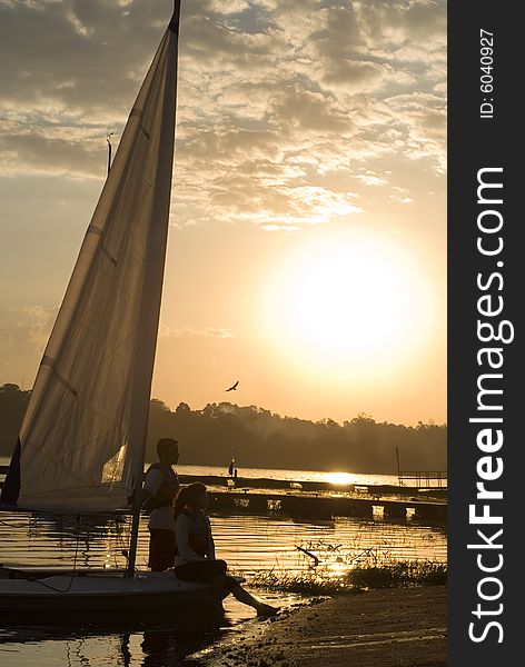 Man And Woman Standing Next To Sailboat - Vertical