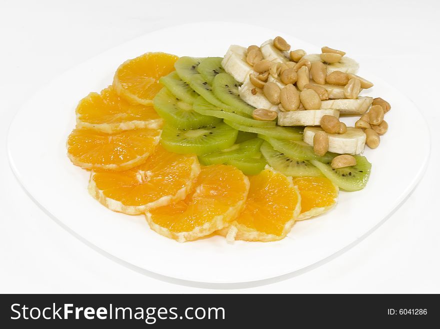 Slices of an orange, a banana and kiwi, from above a peanut. Slices of an orange, a banana and kiwi, from above a peanut