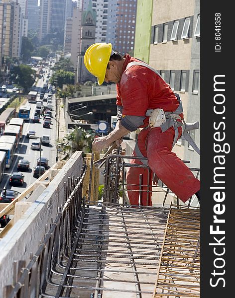 Worker installs rebar on top of building under construction. Vertically framed photo. Worker installs rebar on top of building under construction. Vertically framed photo.
