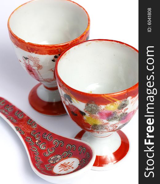 Two tea cups and spoon painted from China on a white background. Two tea cups and spoon painted from China on a white background