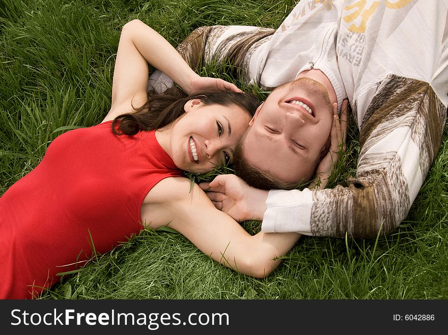 Loving young couple outdoor on the grass. Loving young couple outdoor on the grass