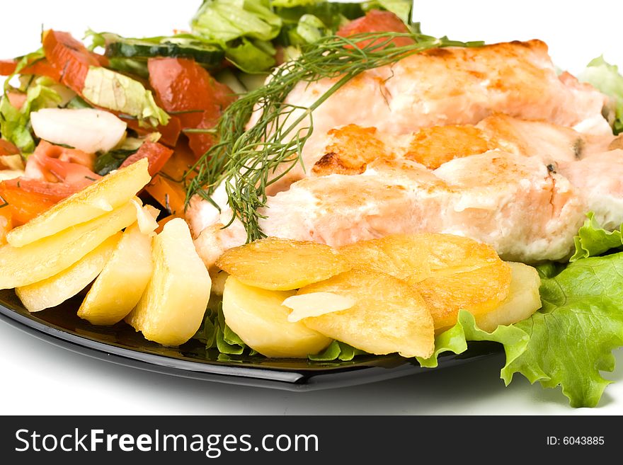 Stake from a salmon with vegetables on a plate. Closeup.