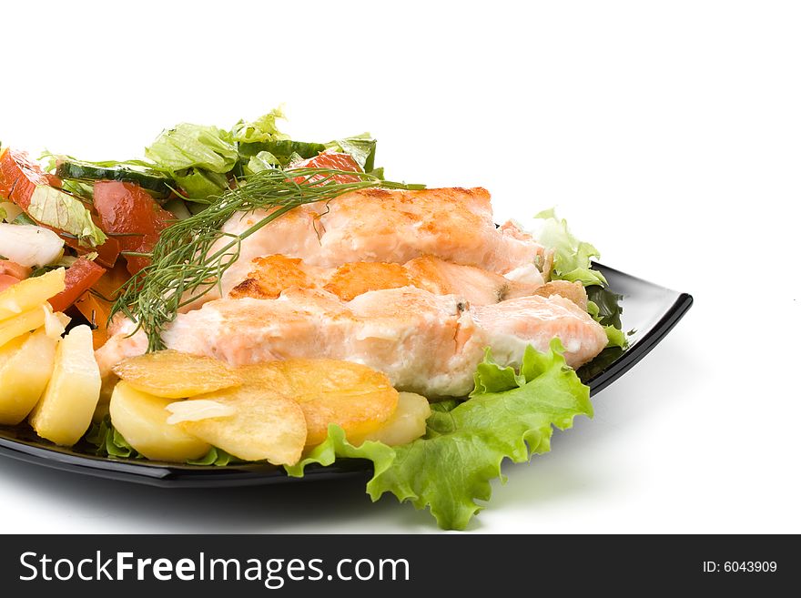 Stake from a salmon with vegetables on a plate. Closeup.