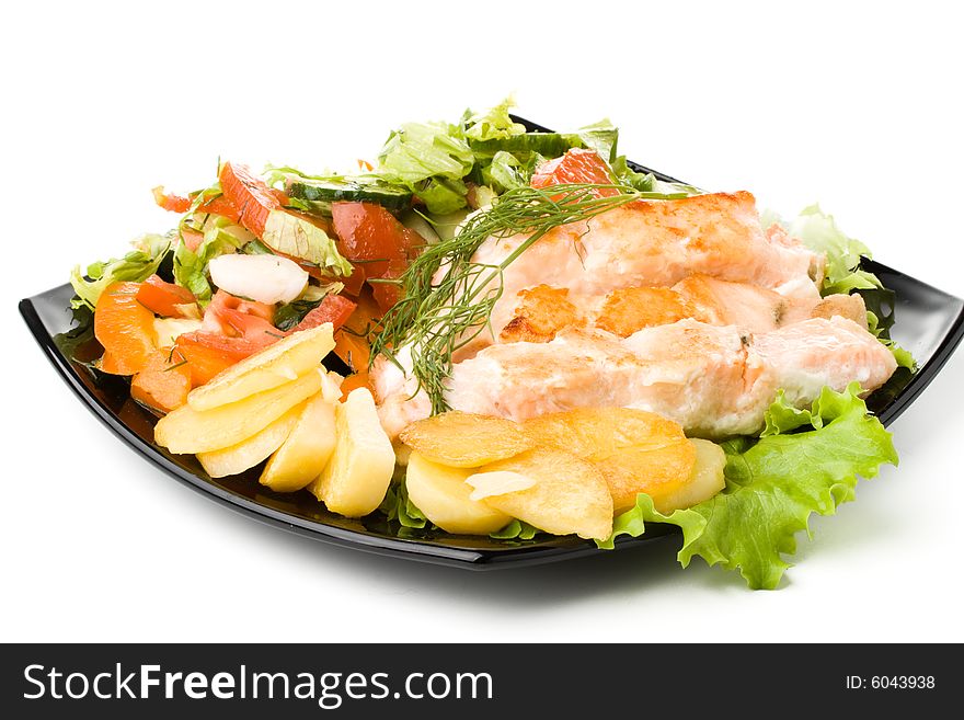 Stake from a salmon with vegetables on a plate. Closeup.